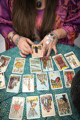 Psychic readings and clairvoyance concept - Fortune teller with hands hold death Tarot card.  Reading tarot divination - obrazy, fototapety, plakaty
