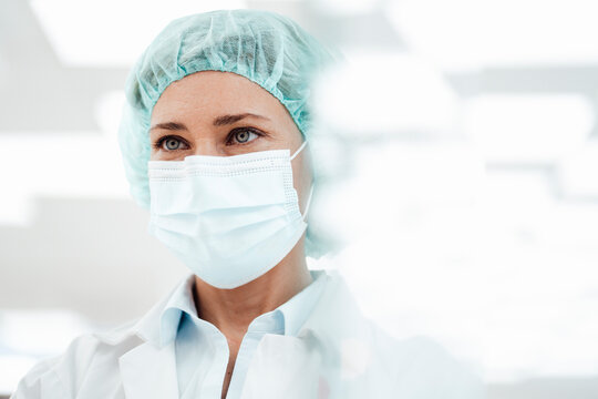 Female pharmacist wearing protective face mask at pharmacy during COVID-19