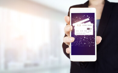 Credit card icon network connection on virtual screen background, business technology. Hand hold white smartphone with digital hologram credit card sign on light blurred background.