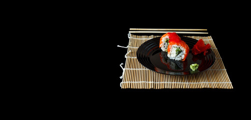 popular food. sushi, pickled ginger on a black plate. Served dish in Japanese style. Sushi chopsticks plate with rolls side view from above. isolated on black background.