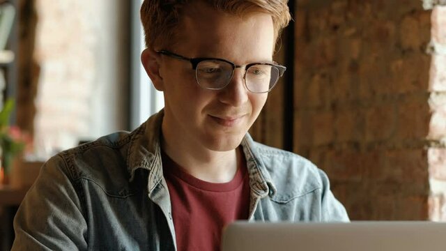 Young professional man using computer and answering phone