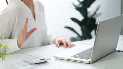 Asian woman working from home talking to colleagues in webcam group video call conference technology 