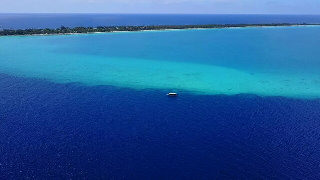 Paradise place. Tropical island in ocean. Boat in blue lagoon. Aerial Drone Fly Over. Carribean, Malvides concept