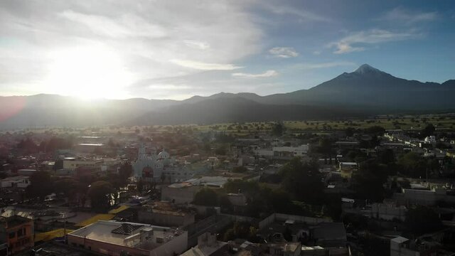 4K drone footage over village at sunset with volcano and mountain range on the back in Tlachichuca, M&eacute;xico.
Mid angle, traveling movement.