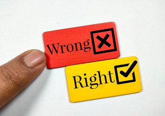 Someone finger show the wrong sign top and bottom written Right on a colored wooden board.