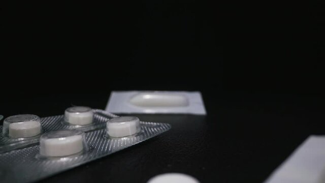 CU, macro: antibacterial suppositories and different colorful medicines to cure virus scattered on dark background extreme close view