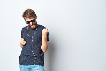 handsome man wearing glasses listening to music on headphones isolated background