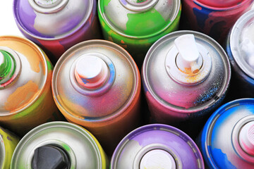 Used cans of spray paints as background, above view. Graffiti supplies