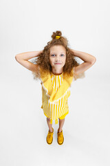High angle view of little cute curly preschool beautiful girl looking at camera isolated over white studio background.