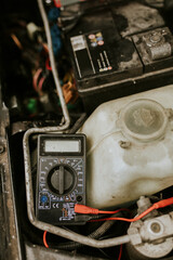 Auto repair using a voltage meter on car battery