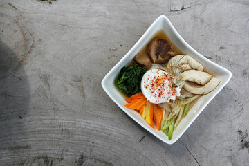 egg soup with chicken and vegetables at white bowl