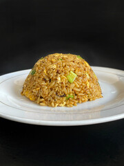 fried rice with chicken and. egg at white plate on black background