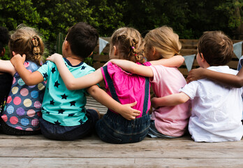 Group of kindergarten kids friends arm around sitting together