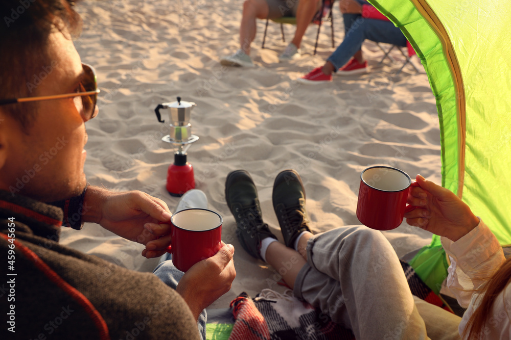 Canvas Prints Friends resting on sandy beach, closeup. View from camping tent