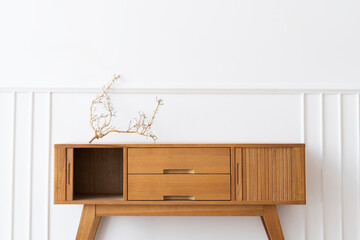Wooden sideboard table against a white wall