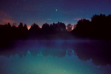 Fototapeta premium Fog on the river on a starry night in the forest. Dubna river, Moscow region, Russia.