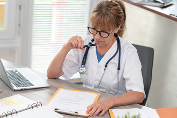 Female doctor reading a clinical record