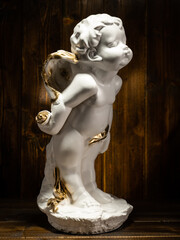 statue sculpture baby angel on wooden background