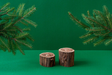 Empty wooden podium and fir tree branches on green background. Eco Christmas concept. Two showcases...