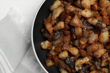 Tasty fried cracklings on white table, top view. Cooked pork lard