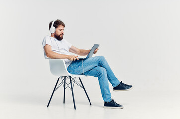 young man sitting on a chair with a laptop in headphones entertainment