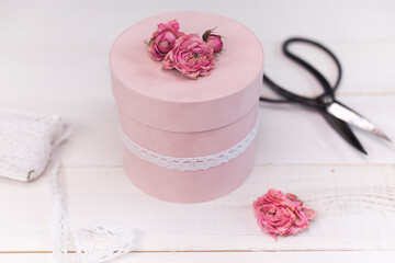 Beautiful pink round gift wrapping is decorated with narrowed roses. 