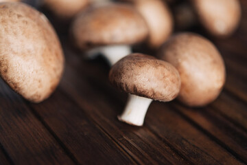 Fresh champignon mushrooms on wooden table