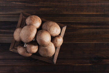 Fresh champignon mushrooms on wooden table