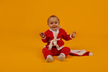 a beautiful little boy in a Santa Claus costume and a Santa hat for the new year