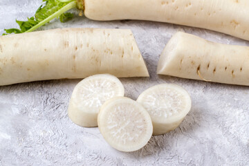 Fototapeta na wymiar Slices of chopped white Daikon radish on a light background