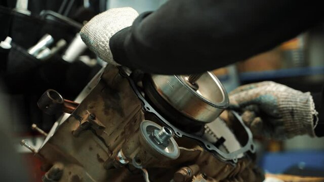 Male locksmith putting on a gasket on an ATV engine