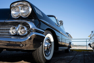 Profile of a black American Classic car on the Santa Monica Beach boardwalk.