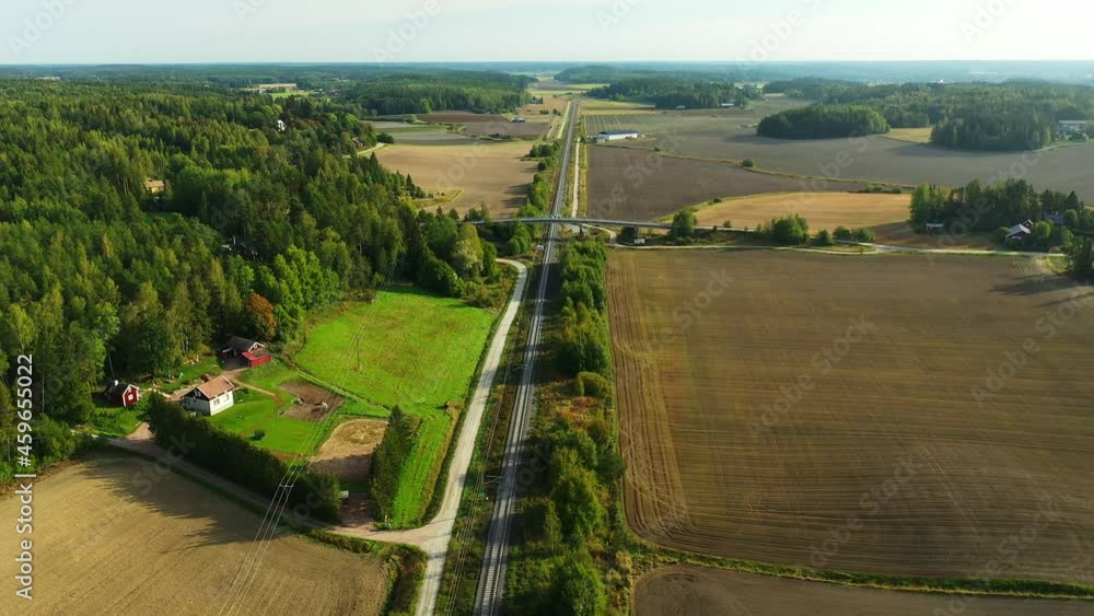 Poster high altitude aerial drone view moving backwards following above long straight electrified railroad 