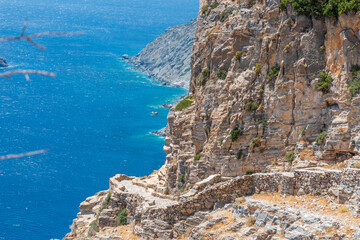 view of the stone road leading tothe famous Hozoviotissa Monastery that standis on a rock over the Aegean sea in Amorgos island, Cyclades, Greece.