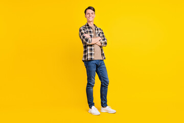 Fototapeta na wymiar Photo of cheerful self-assured guy crossed hands wear plaid shirt jeans shoes isolated yellow color background