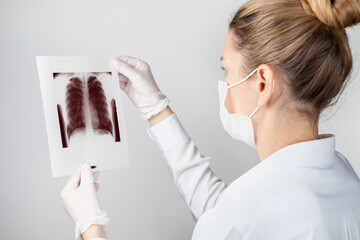 Close-up of a female doctor or scientist in a protective mask with a shot of the lungs. Medicine,...