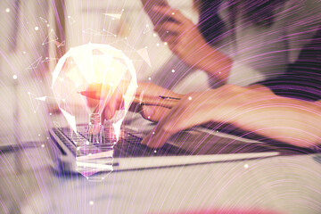 Double exposure of woman hands typing on computer and light bulb drawing. Idea concept.