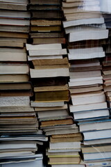 Empilement de livres anciens dans une vitrine de librairie.