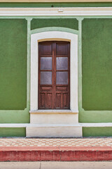 Rustic green colored facade with an antique wooden village window