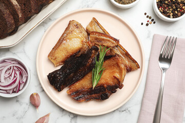 Tasty fried pork lard with rosemary on white marble table, flat lay
