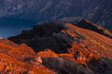 Fototapeta na wymiar Reflection of orange sky on the summit of Mount Rinjani at sunset, Lombok, Indonesia