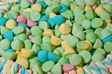 Texture of multicolored candies. Sweets on a pile close up. Sweets shop window.