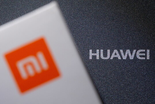 Xiaomi and Huawei logos are seen on smartphone boxes in this illustration