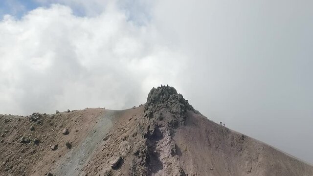 Aerial shot of hikers in the summit of La Malinche Volcano in Mexico. Showing the cliffs and cloudy weather.