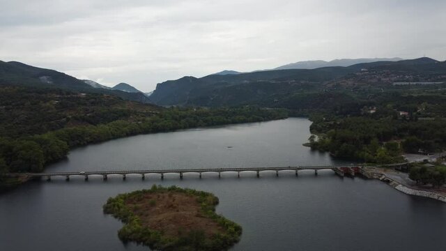 Car crossing a bridge on Haliacmon river in northern Greece. Aerial drone approaching cine shot