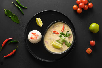 Spicy creamy Tom Kha Gai soup with chicken, cherry tomato, coconut milk, kaffir, galangal,...