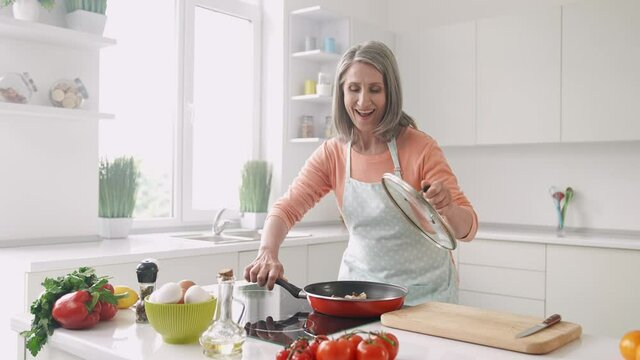 Positive cook teacher lady open fry pan smell gourmet reaction