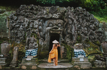 Beautiful girl visiting the goa gajah temple in ubud , Bali