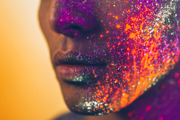 Handsome boy dancing at the rave party with fluorescent paintings on his face