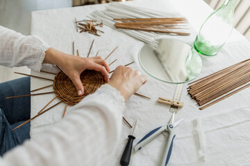 Mature woman making paper vine basket at home